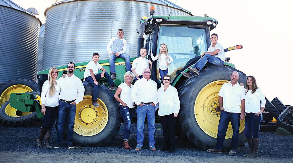 All 12 members of the Berg family posed around a John Deere tractor